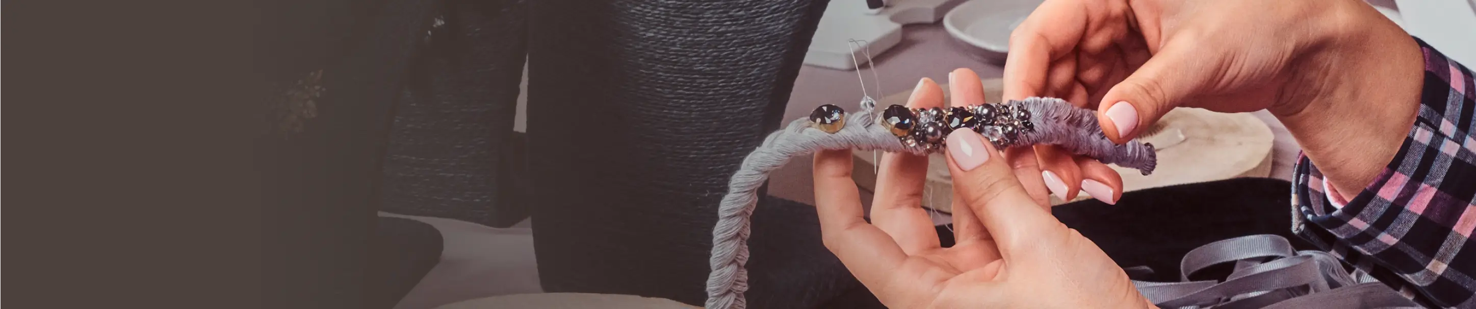A jeweler threading pearls onto a bracelet at the bench