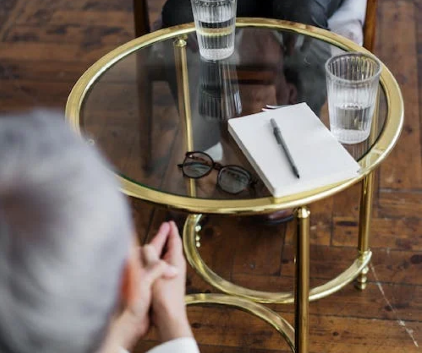 A client seated at the consultation table with a notebook and loupe