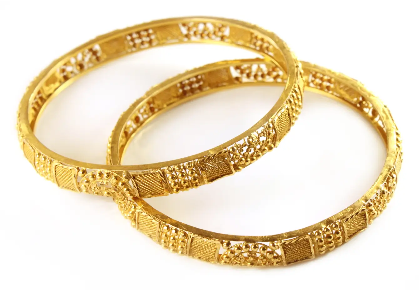 Two textured gold bangles, one resting on the other